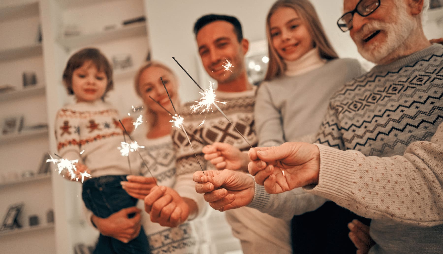 The happy family with bright sparklers during the holiday season, spending time together