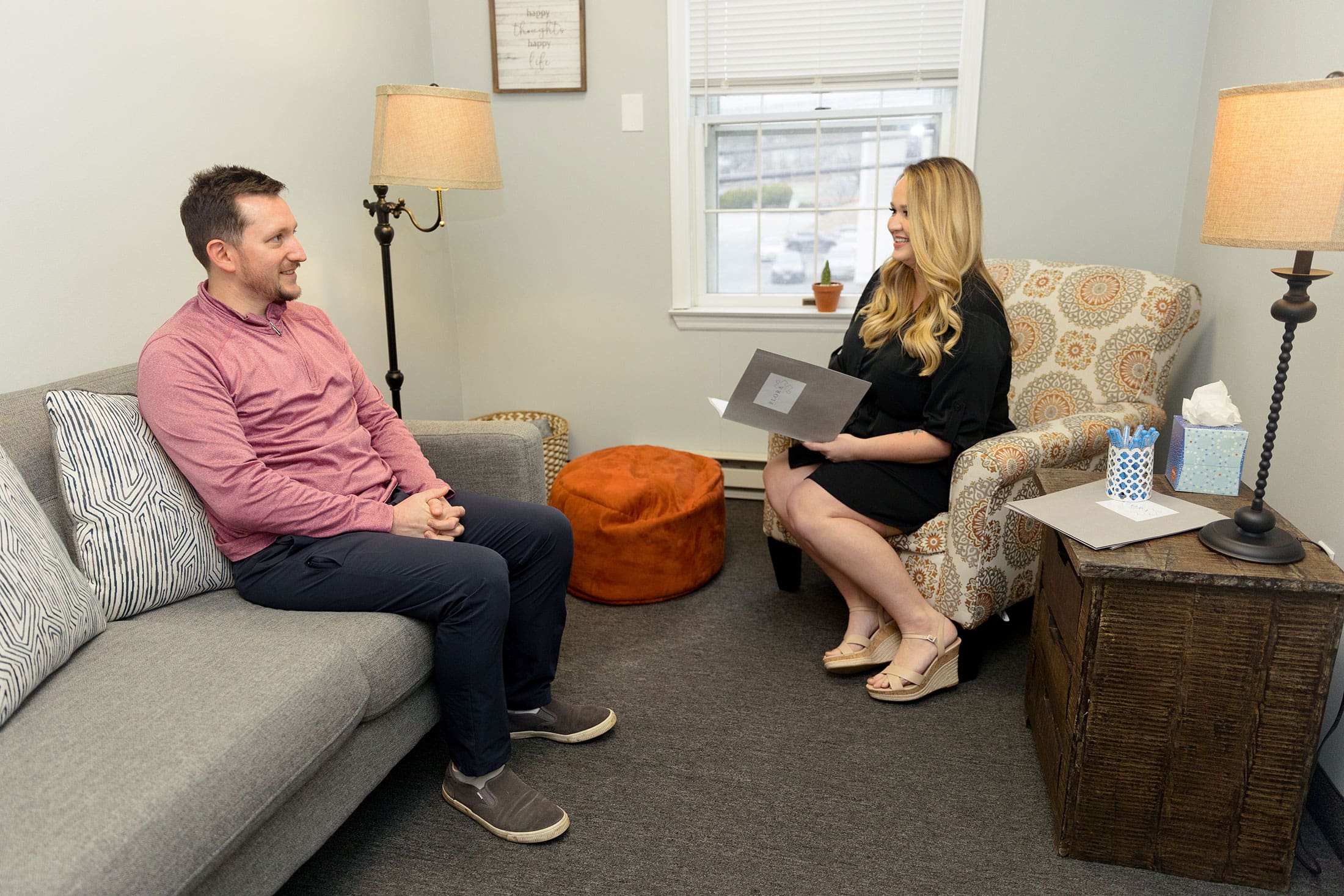 A therapist in a consult room with a patient that is a dad, he is there for parent coaching