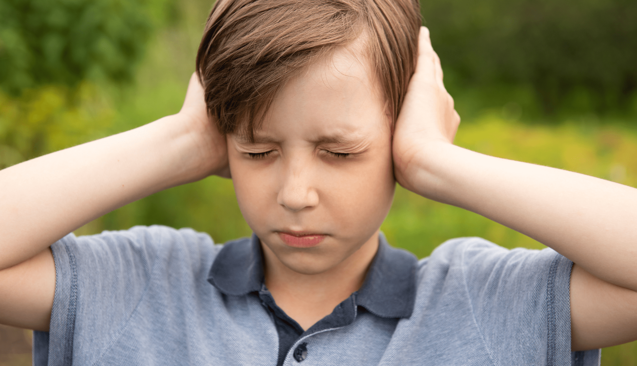 Little Caucasian boy closing ears with his hands. Childhood traumatic experience, psychology