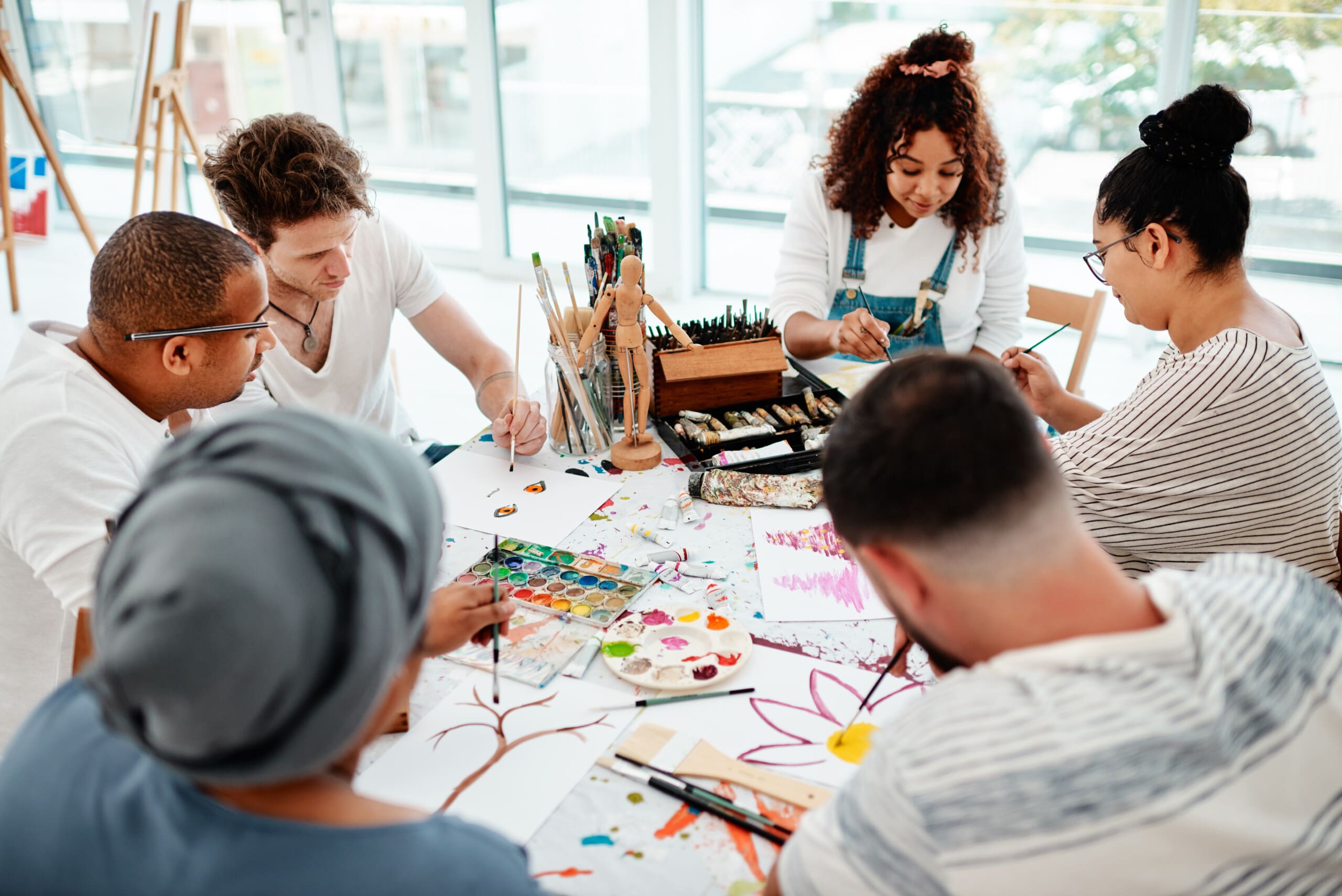 The language of friends is not words but meanings. A group of young adults engaging in a group activity of painting and art therapy.